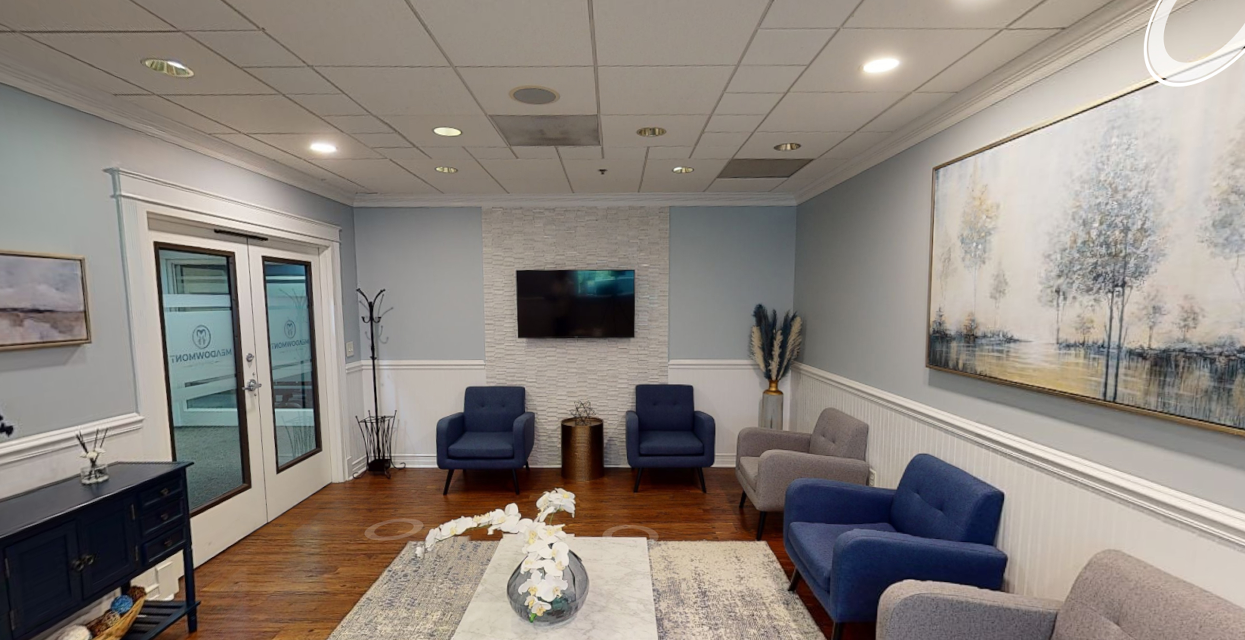 Bright waiting room interior with sofas and framed artwork — Meadowmont Dentistry in Chapel Hill, NC