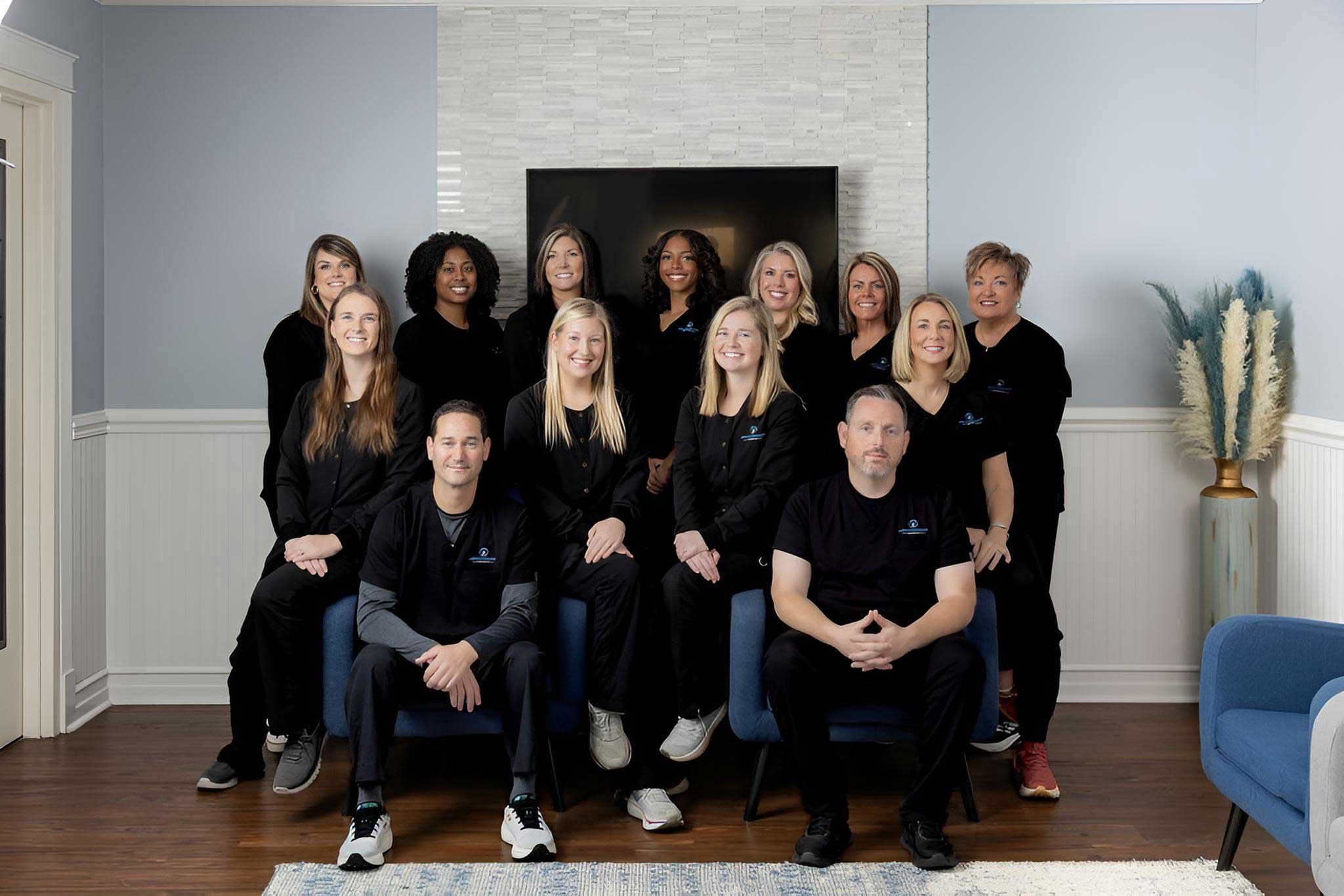 Team group photo posed outside the office building entrance — Meadowmont Dentistry in Chapel Hill, NC